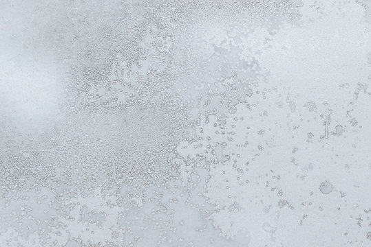 Frosty pattern on the window. Texture of the ice and snow on the glass. Abstract winter background. Close-up