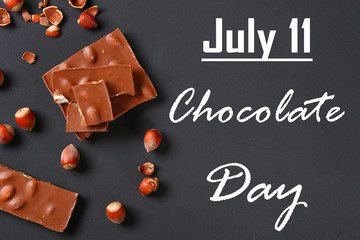 Chocolate with hazelnuts, mint and grains of coffee on a dark gray table. Top view. July 11 is the day of chocolate.