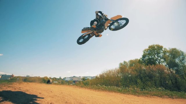Panoramic view of a racer's jumping trick performed on a motorcycle. Slow motion