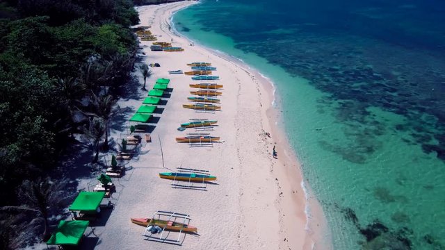 Aerial drone shots of a white sand beach with blue waters in an exotic place in the Philippines, southeast asia