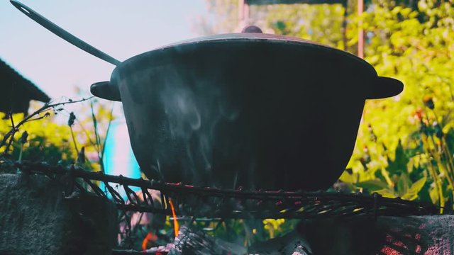 kitchen outdoors.cooking at the stake. metal cauldron  on the fire amid vegetation.close-up.