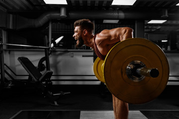 Sports background. Young athlete lifts barbell to his chest. Concept workout