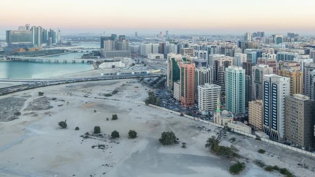 Aerial skyline of Abu Dhabi city centre from above day to night timelapse