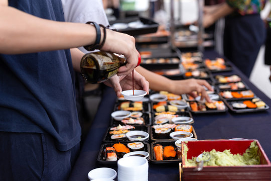 Selected focus hand pouring sushi sauce with wasabi on thailand street food Japanese sushi