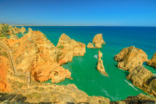 Aerial view of long staircase leading to the base of cliffs of Ponta da Piedade in Lagos Bay. Sandstone formations in Lagos, Algarve Coast, Portugal. Summer holidays. Tour tourism in Atlantic Ocean.