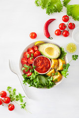 vegan buddha bowl. healthy lunch bowl with avocado, tomato, sweet corn and salsa