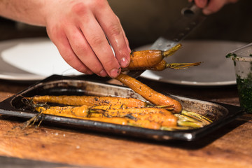 Obraz premium Chef cooking in restaurant. Grilled carrot.