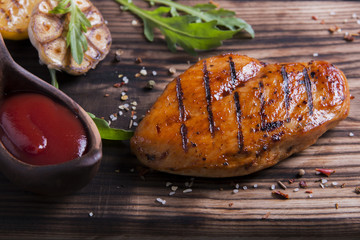 Grilled chicken fillet with sauce,garlic and lemon on wood
