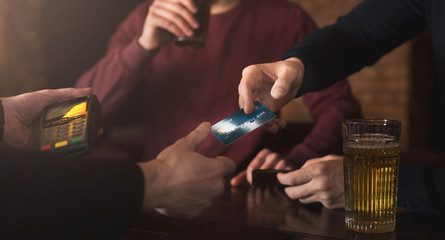 Bartender accepting credit card at bar counter