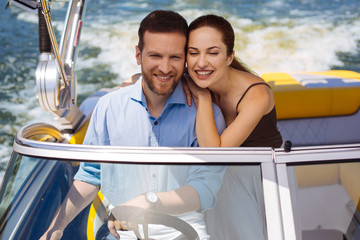 Perfect purchase. Happy young couple having a maiden voyage on their new yacht and smiling happily