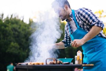 Handsome male preparing barbecue