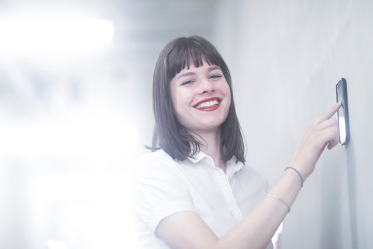 Woman using wall mounted touch screen control panel