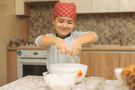 Cute boy spreading flour with hands