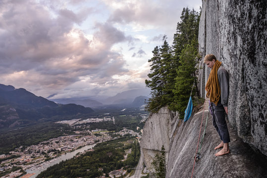 Young male climber standing barefoot on bellygood ledge, The Chief, Squamish, Canada
