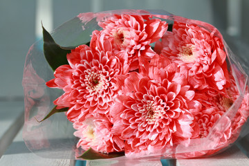 Colorful pink rose flowers bouquet is a combination rests on white wood.