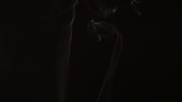 White smoke rising up on black background