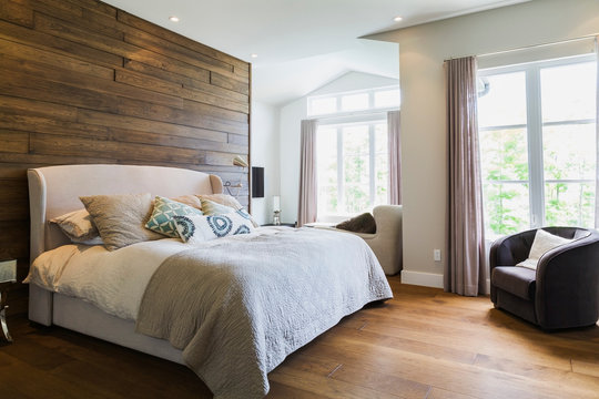King size bed in bedroom with hickory wood floorboards