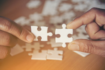 Hand holding jigsaw puzzles, Business partnership concept.