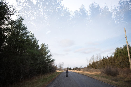 Girl rollerblading on country road, Bath, Canada