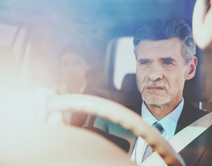 Driver in Luxury Car with Woman on Back Seats.