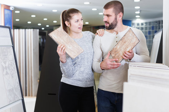 Cheerful Couple Looking Sample Of  Ceramic Tile