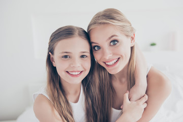 Close up portrait family photo of cute sweet lovely beautiful charming glad cheerful with toothy beaming smile mum and her pretty daughter embracing neck spending time together domestic life