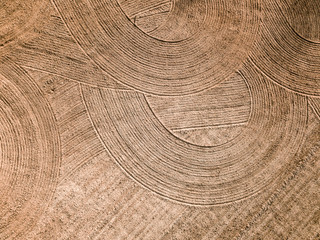 Naklejka premium Spring arable land. Field and beautiful patterns from the tractor. View from above. 