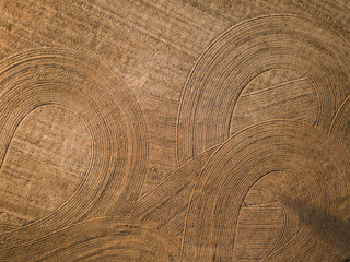 Naklejka premium Spring arable land. Field and beautiful patterns from the tractor. View from above. 