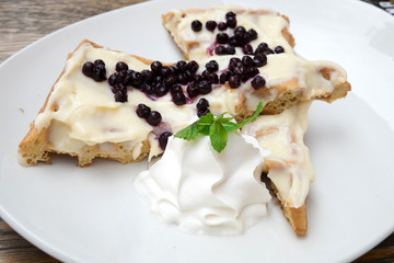Delicious traditional Belgian homemade waffles with sweet vanilla sauce, fresh blueberries and whipped cream served at the confectionery of Novi Sad, Serbia