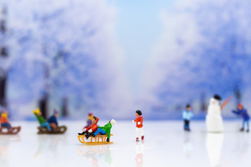 Miniature people: Children playing on snow funny together. Image use for Christmas festival