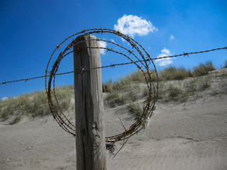 Dunes with barbed wire at the beach