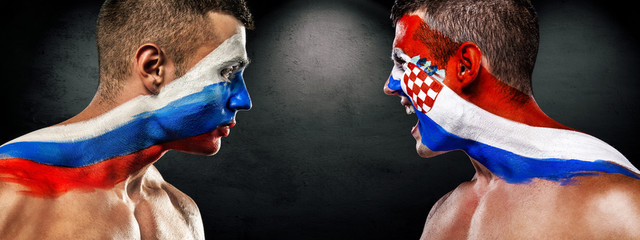 Soccer or football fan with bodyart on face with agression - flags of Russia vs Croatia. Sport Concept with copyspace.