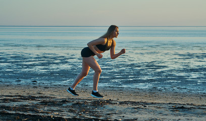 Woman jogging at evening beach