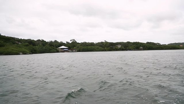 Slow motion wide angle clip of Dixon Cove in Roatan, Honduras from a small boat.