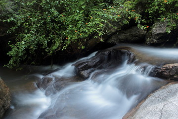 Tropical yoga session by beautiful Sticky Waterfall close to Chiang Mai in north Thailand.