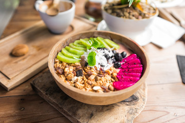 healthy eating, dieting, vegetarian food and people concept - close up of fruits and berries in bowl on wooden table