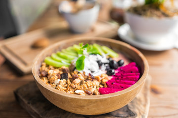 healthy eating, dieting, vegetarian food and people concept - close up of fruits and berries in bowl on wooden table