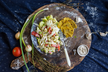 Rw vegan zucchini spaghetti with corn bread slices. Salad with red bell pepper, tomatoes, cucumbers...