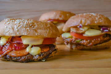 Juicy fresh burgers with a meat chop. Hamburger, cheeseburger, with tomato and salad and knife