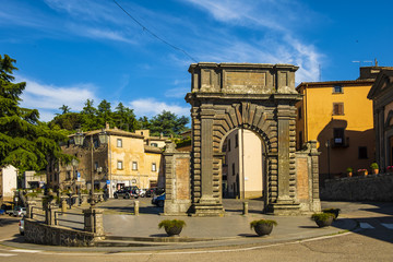 Fototapeta na wymiar Bagnoregio, Italy - Ancient Roman gate arch in historic center of old town quarter at Piazza di Porta Albana square