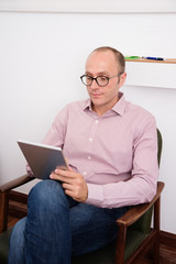 Man holding a pc tablet as he reads
