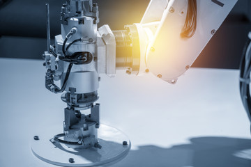 The robotic arm for handing the part in factory in light blue scene .Modern factory for industrial 4.0 manufacturing process.