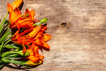 Orange lilies on rustic wooden background