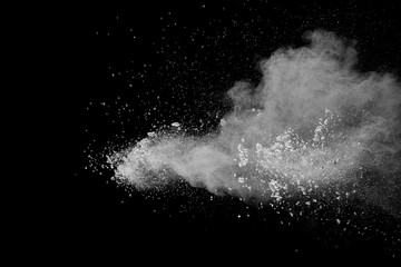 Bizarre forms of  white powder explosion cloud against dark background. Launched white dust particle splash on black background.