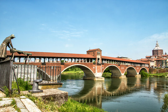 Ponte coperto a Pavia con riflesso, statua della lavandaia e Duomo sullo sfondo