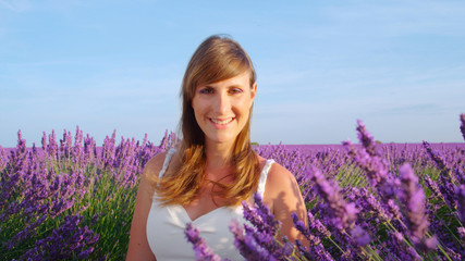 Young woman enjoying in a blooming lavender field in France