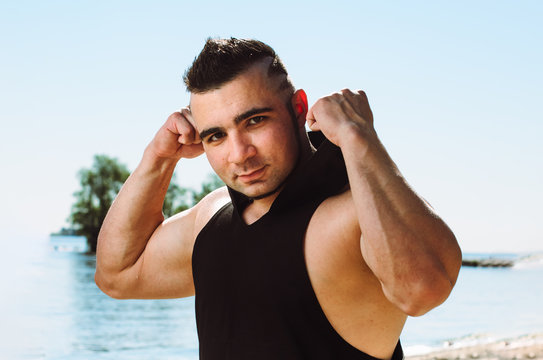 the athlete on the beach posing. the guy is an athlete shows his muscles
