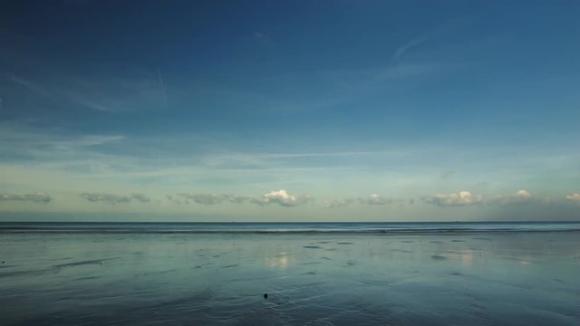 Time lapse of low tide seascape with clouds reflected on the wet sand. The beach of the English channel in Normandy, France. Dramatic cloudy sky. Cloudscape, calmness, meditation and relax concept