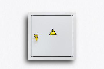 Grey Hinged Power Supply Box with yellow keys on the White Wall