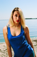 Naklejka premium the athlete on the beach posing. blonde girl with big eyes posing